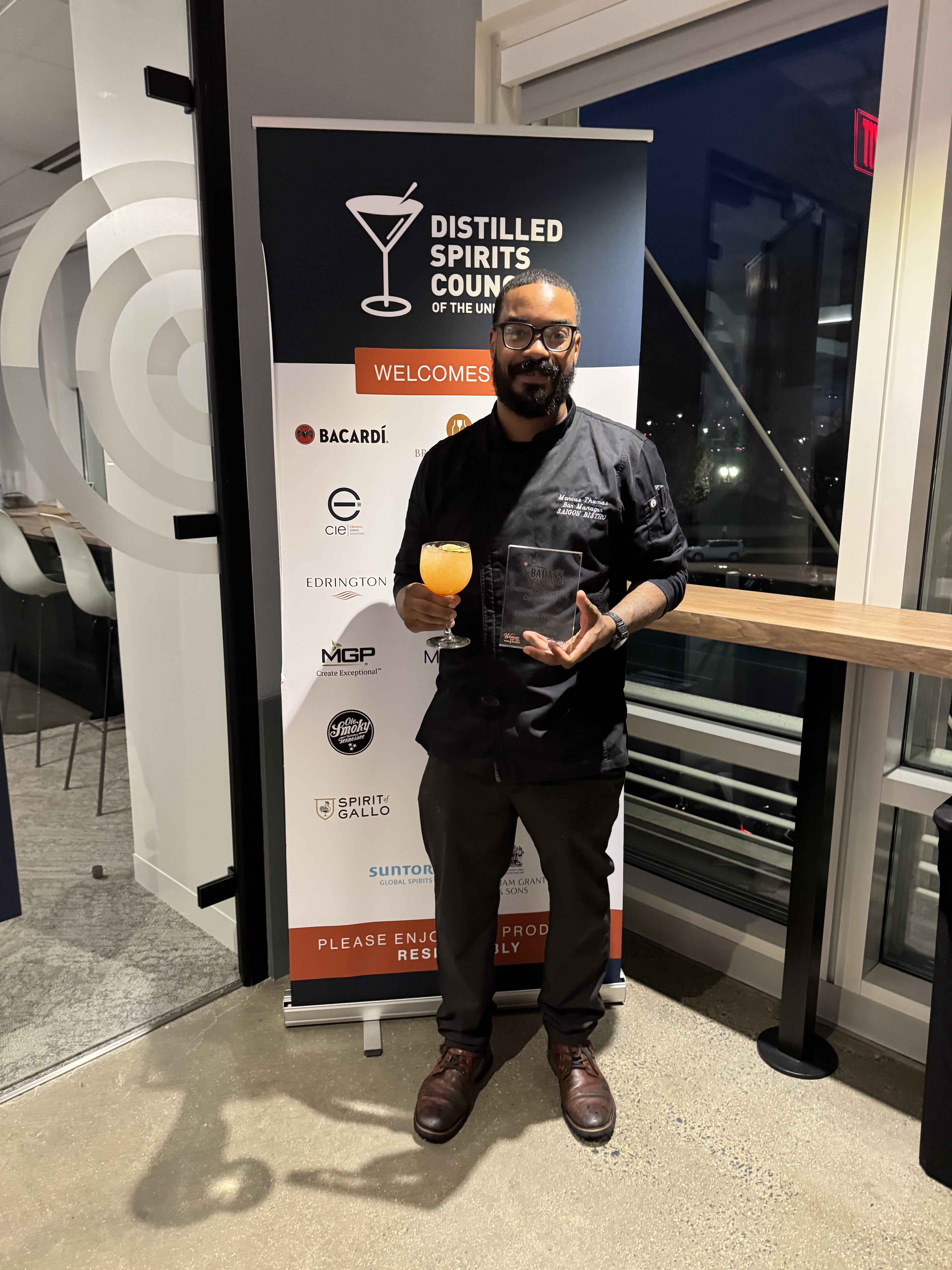 Marcus Thomas holding his trophy as 2026 DISCUS National Cocktail Day Competition Champion in Washington DC